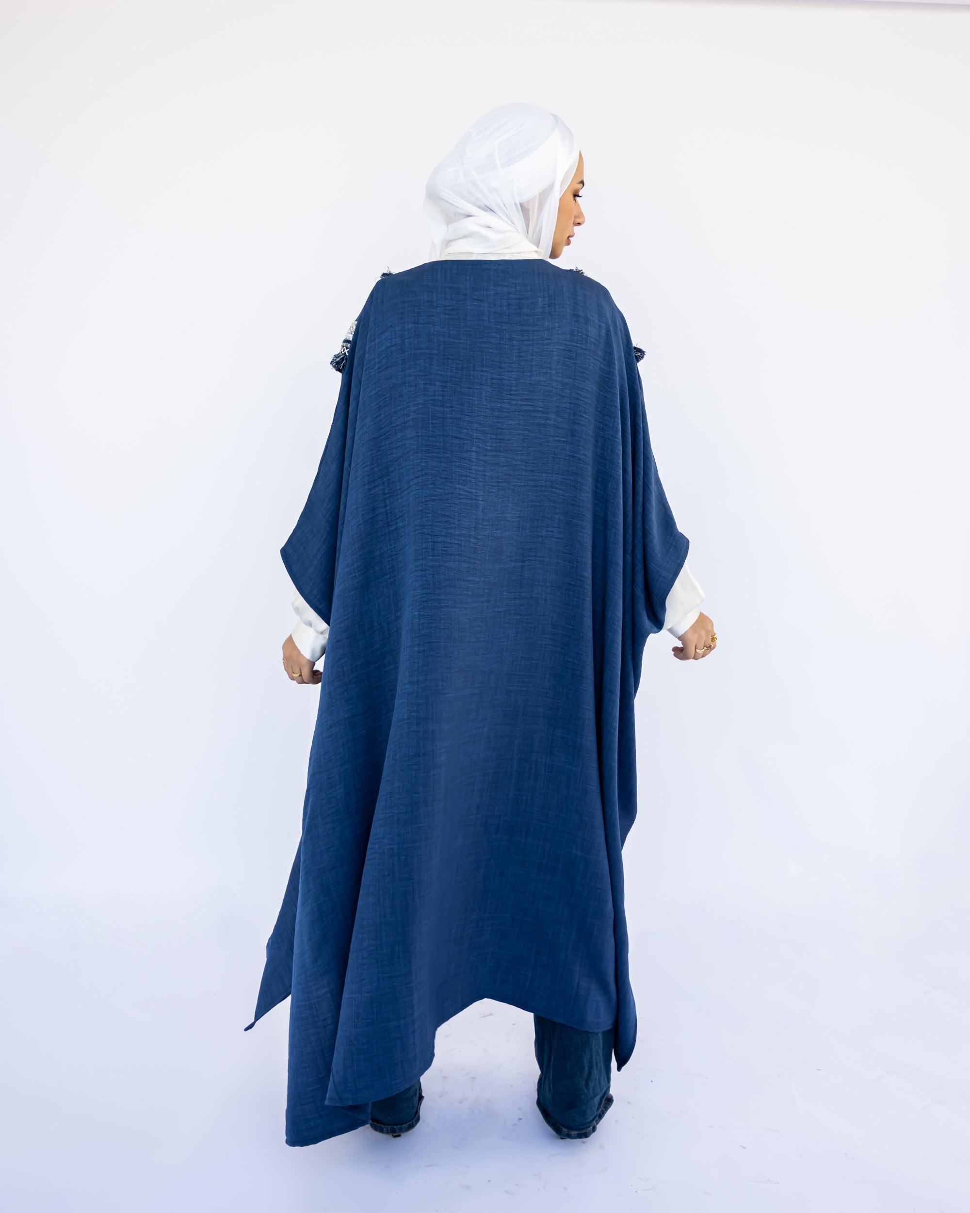 Enchanted V-Neck Cape in Turkish linen-cotton with imported Arabian taps and fluid drape, a striking free-size kaftan in beige, black, blue, or white